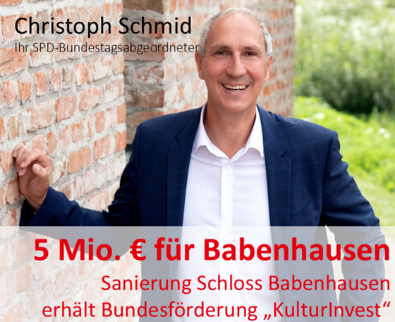 MdB Christoph Schmid lehnt an eine Steinmauer an