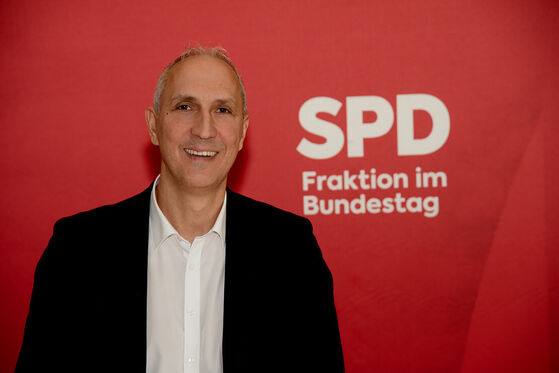 MdGB Christoph Schmid steht vor einem roten Banner der SPD-Bundestagsfraktion